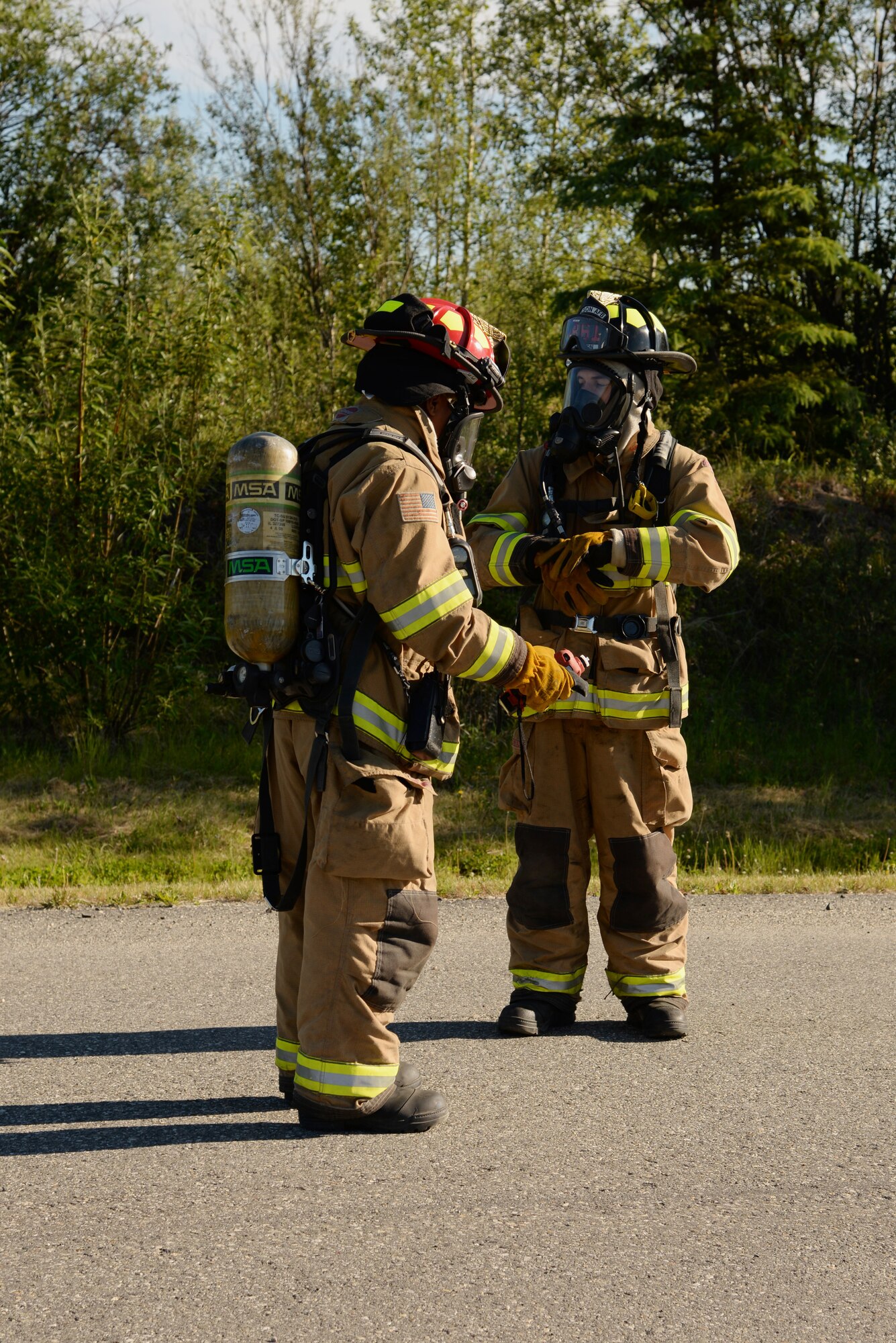 U.S. Air Force firefighters from 354th Civil Engineer Squadron Engine 82 prepare to approach the site of a simulated large-scale 4.2-million gallon fuel spill during an exercise June 17, 2015, at Eielson Air Force Base, Alaska. The exercise is a Federal requirement conducted tri-annually to train and prepare fuels management and emergency services personnel in minimizing the environmental impact of a spill and in protecting and preserving public health and safety. (U.S. Air Force photo by Staff Sgt. Kirsten Wicker/Released)