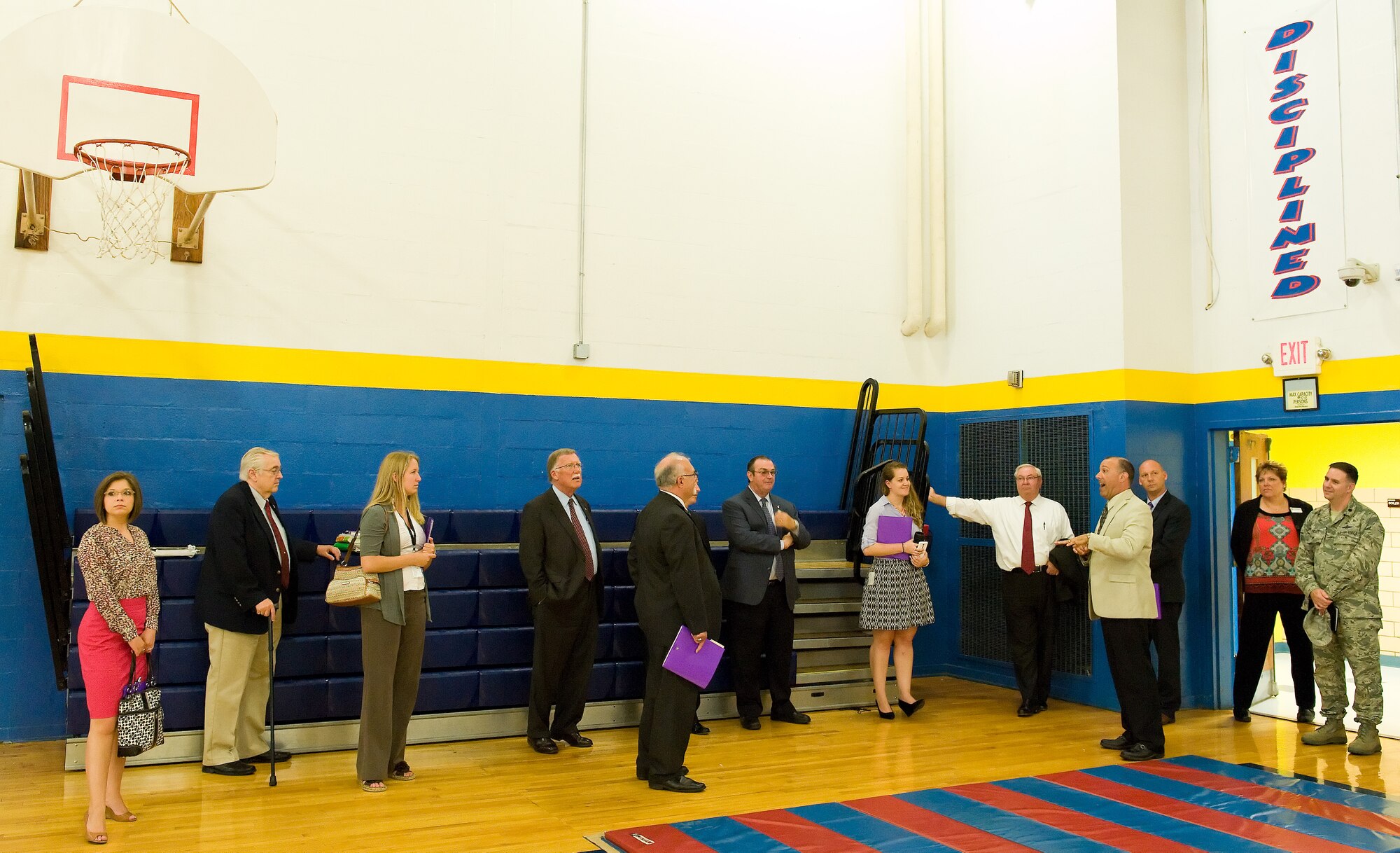Dr. David Santore, Dover Air Force Base Middle School principal, fourth from right, take Delaware state legislators and staff members on a tour of the gym June 9, 2015, on Dover Air Force Base, Del. Legislators and staff members toured numerous DAFB Middle School classrooms as well as classrooms at George S. Welch Elementary School. (U.S. Air Force photo/Roland Balik)
