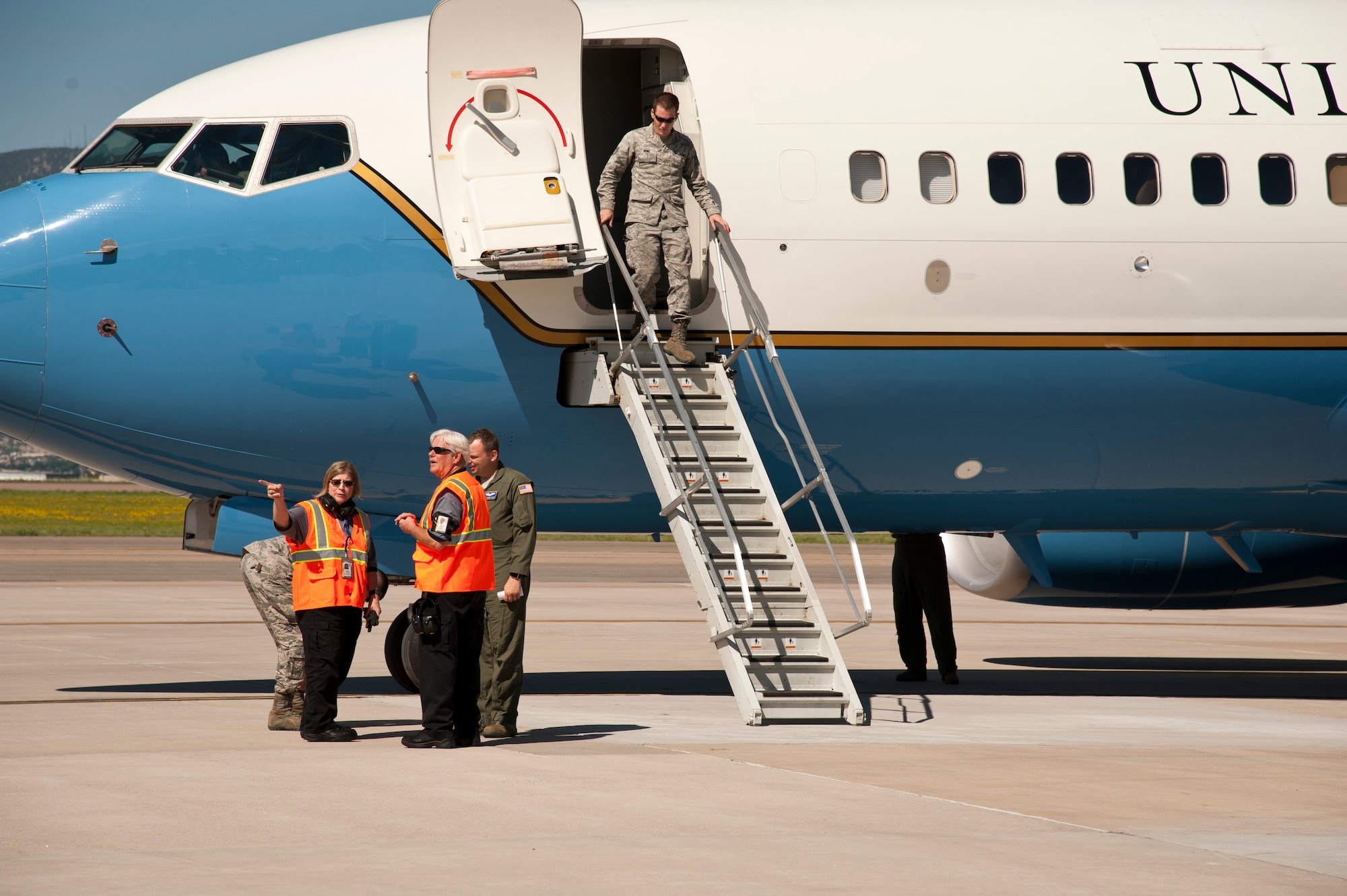 PETERSON AIR FORCE BASE, Colo. – Karen Mitchell and Chuck Fettes, 21st Operations Support Squadron transient alert, coordinate maintenance needs with an incoming C-40 Clipper air crew from Scott Air Force Base, Illinois on June 17, 2015. Mitchell and Fettes are part of a nine-member servicing crew who escorts, coordinates services, fuels, and supports all aircraft to and from Peterson. (U.S. Air Force photo by Senior Airman Tiffany DeNault)