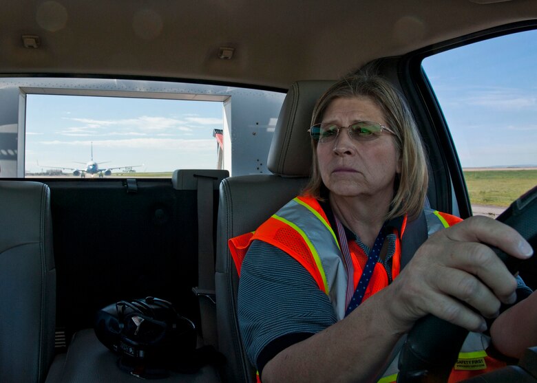 PETERSON AIR FORCE BASE, Colo. – Karen Mitchell, 21st Operations Support Squadron transient alert lead servicer, escorts a C-40 Clipper from Scott Air Force Base, Illinois, to its parking spot June 17, 2015. This is Mitchell’s 19th year as part of a nine member servicing crew who escorts, coordinates services, fuels, and supports all aircraft to and from Peterson. (U.S. Air Force photo by Senior Airman Tiffany DeNault)