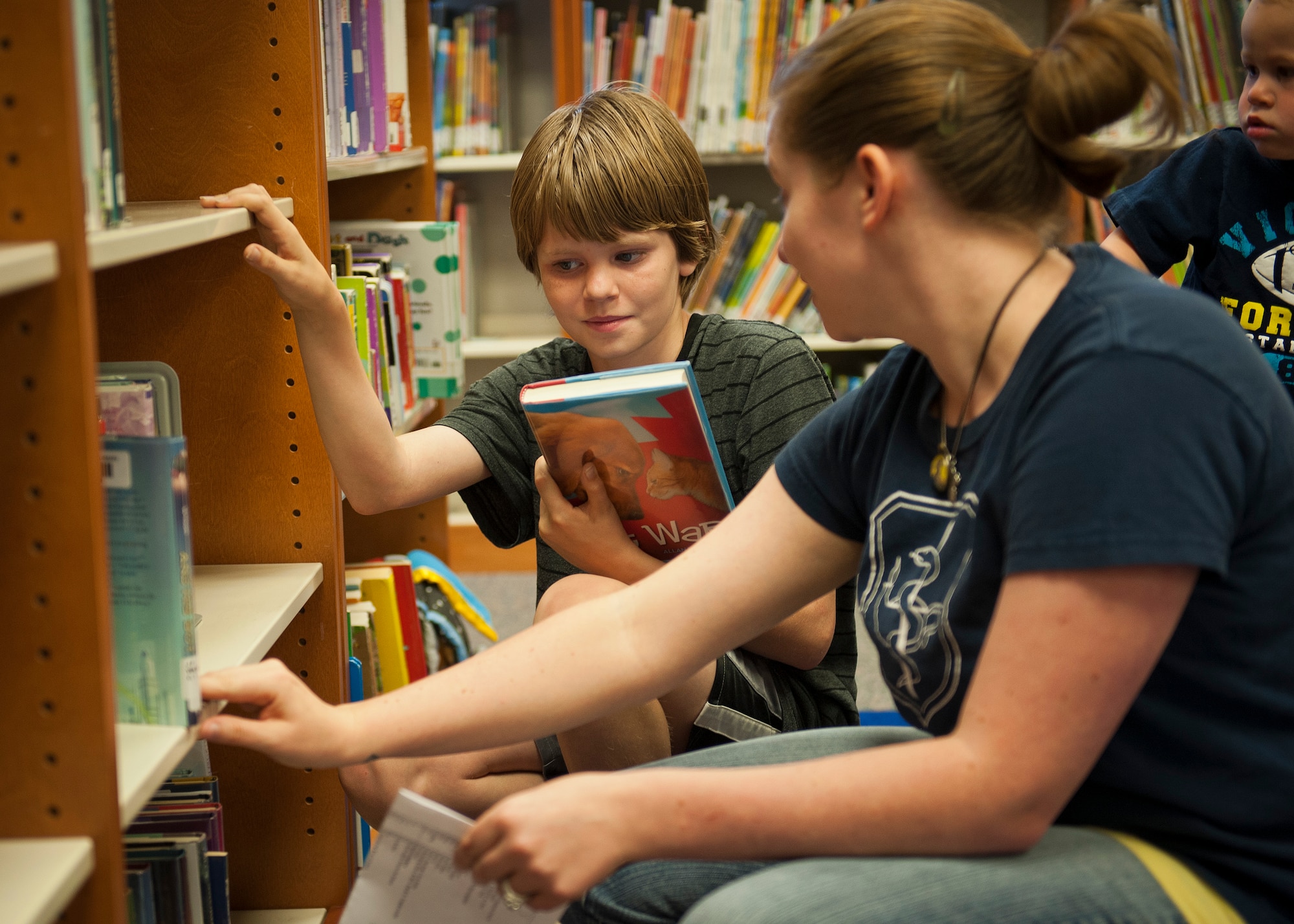 PETERSON AIR FORCE BASE, Colo. – Nathan Sharp, 11 , picks out a new book with his mom, Roze Sharp, at the Peterson AFB Library, June 16. Roze’s husband works at Schriever, which does not have a library, so she came to Pete and signed all three of her kids up for the summer reading program to keep them engaged in educational activities. (U.S. Air Force photo by Airman 1st Class Rose Gudex)