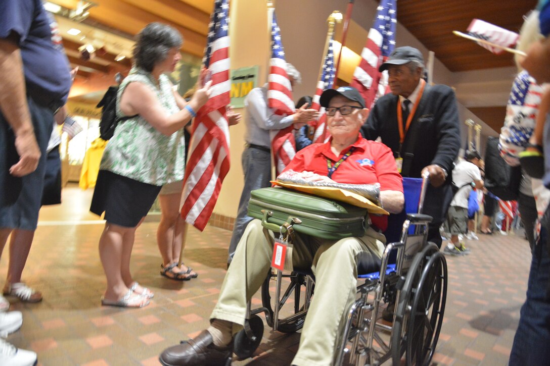 World War II veterans return to Albuquerque International Sunport Friday and are greeted by more than 200 people dressed in patriotic clothing and waving flags. (Photo by Todd Berenger)