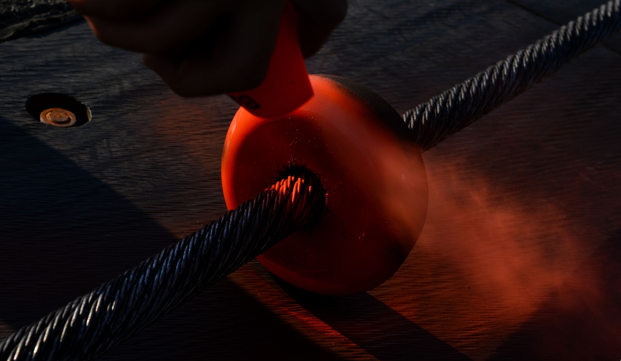 The steel cable an aircraft's tailhook would grab in the event of an emergency is held slightly more than two inches off the ground, in part, by rubber donuts and is one part of the BAK-12 aircraft arresting system. The donuts in the center of the runway are spray-painted so a pilot can more easily hook the center of the cable in the event of an emergency. (U.S. Air Force photo/Airman 1st Class Kyle Johnson)