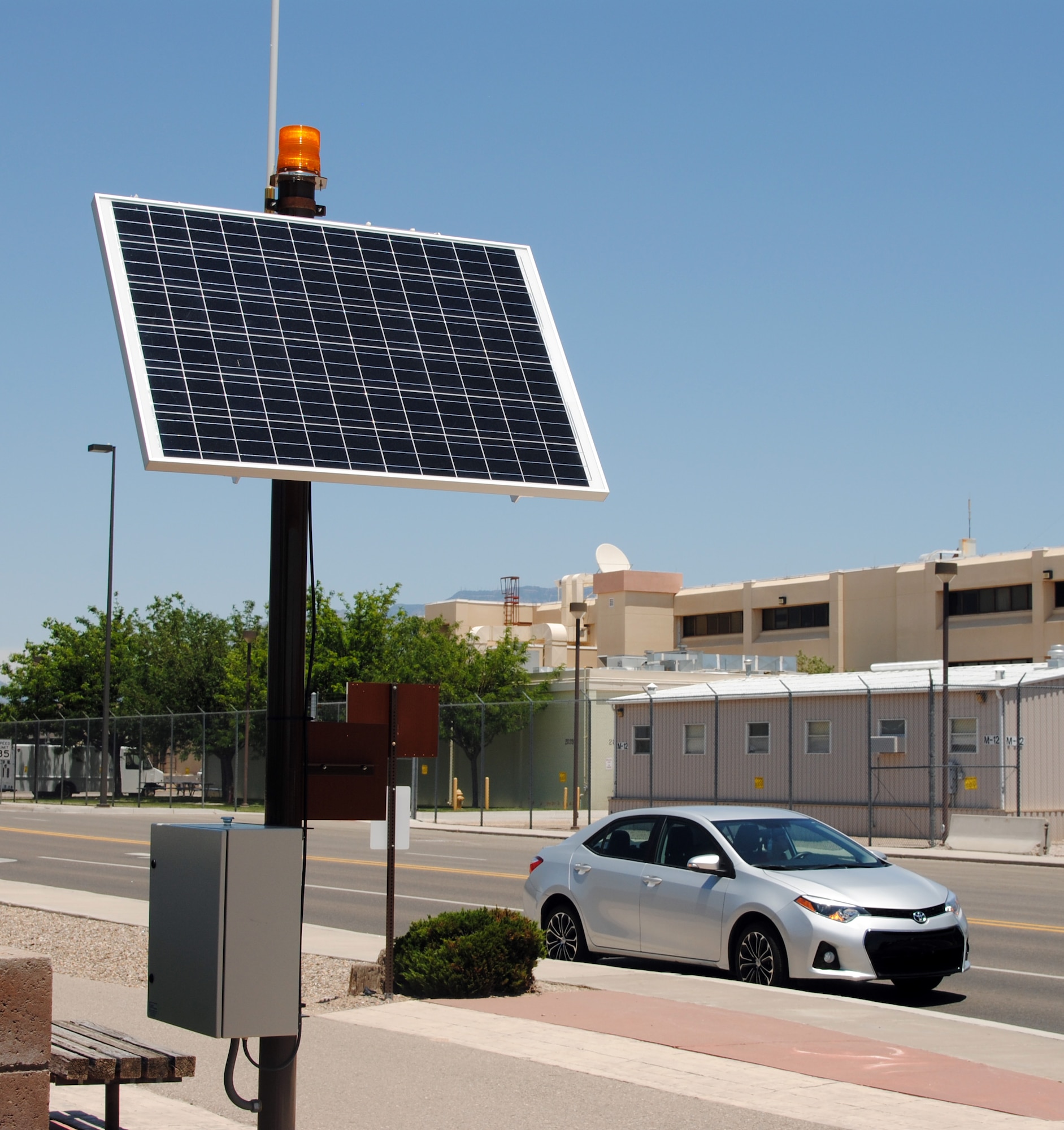 A car pulls over while an alert route beacon tower flashes on Texas Street recently. The beacons have been installed to ensure aircrews can travel to the flightline quickly and safely. The flashing yellow lights are a warning for motorists of potential emergency vehicles traveling on the route and motorists are advised to pull over and stop for any approaching emergency vehicle with lights and sirens. Drivers should pull over to the far right as safely as possible, and come to a complete stop, then wait for alert vehicles to pass and beacons to stop flashing before proceeding. (Photo by Jim Fisher). 