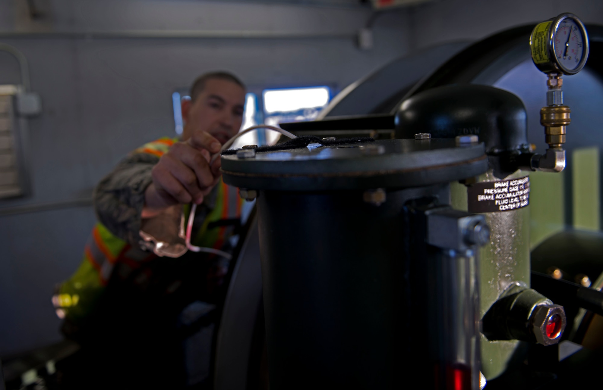 Senior Airman Joshua Ray, a power production journeyman with the 773d Civil Engineering Squadron, checks for air pockets in the hydraulic fluid as part of his weekly inspection of the BAK-12 aircraft arresting system. The BAK-12s on the flightline of Joint Base Elmendorf-Richardson are designed to bring out-of-control aircraft to a safe stop with minimal damage. (U.S. Air Force photo/Airman 1st Class Kyle Johnson)