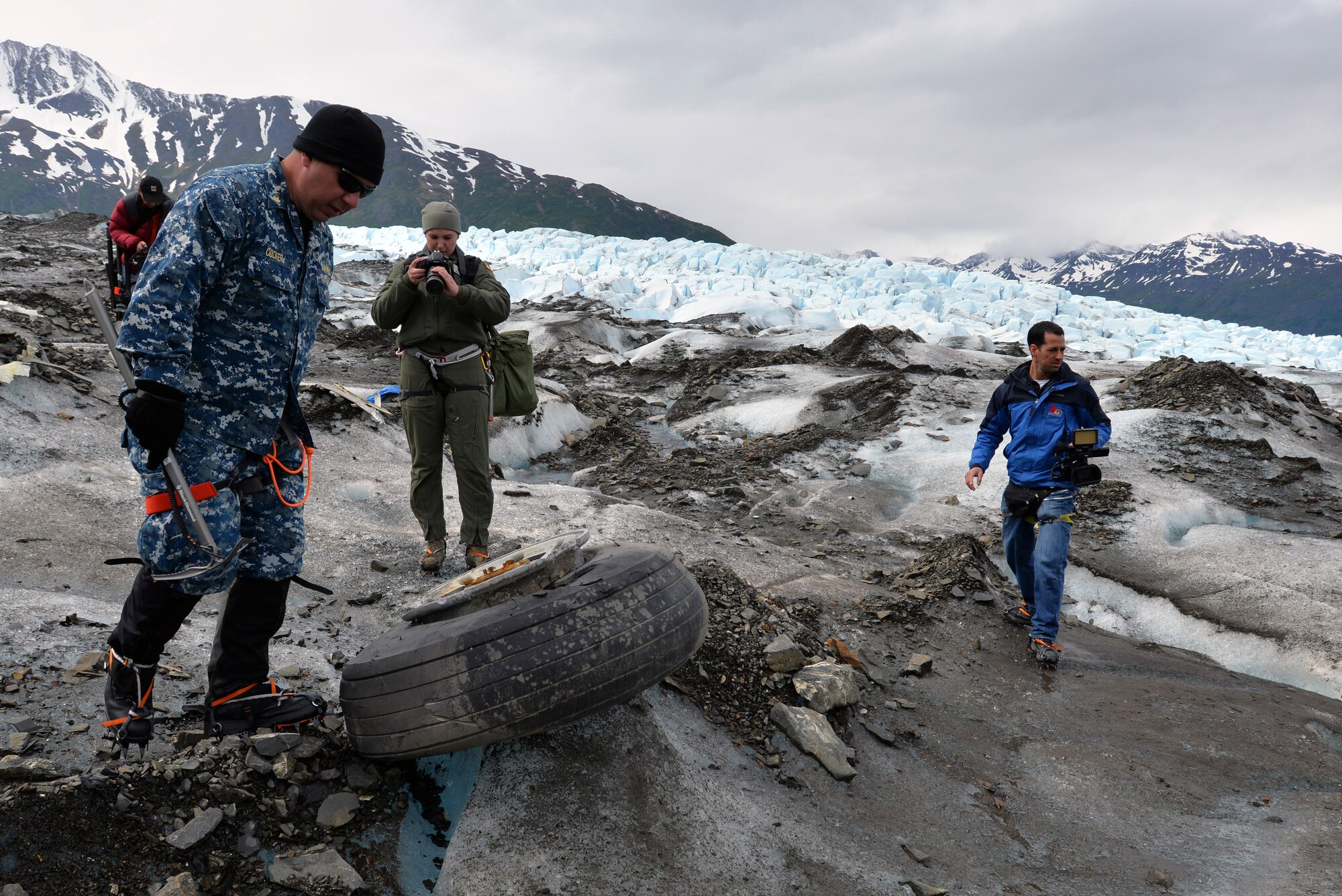 Navy Lt. Commander Paul Cocker (left), Alaskan Command deputy chief of future operations and Operation Colony Glacier project officer, shows local media some of the aircraft debris from the 1952 C-124 Globemaster II aircraft accident June 10. Each summer since 2012 Alaskan Command has supported Operation Colony Glacier by removing aircraft debris and assisting in the recovery of human remains to ensure closure for families who have lost loved ones.  (U.S. Air Force photo/Tech. Sgt. John Gordinier)