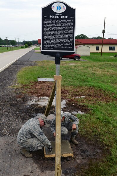 Airman 1st Class Zachary Aronin, left, and Senior Airman Douglas E. Skelton II, 2nd Civil Engineer Squadron paving and equipment technicians, install a memorial sign on Barksdale Air Force Base, La., June 18, 2015. The sign was installed in order to preserve and inform Airmen about Barksdale’s rich history. (U.S. Air Force photo/Airman 1st Class Luke Hill)