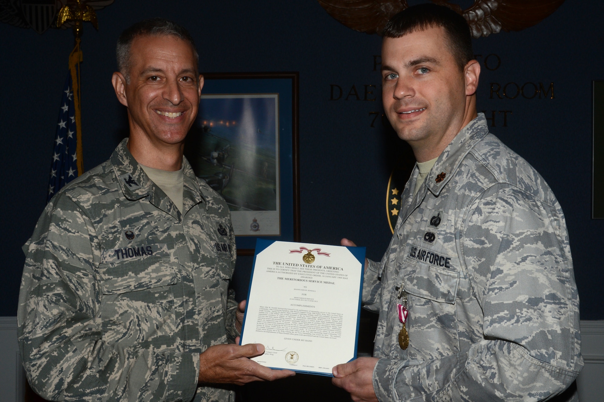 U.S. Air Force Maj. John Kendall, 20th Contracting Squadron commander, receives the Meritorious Service Medal from Col. John Thomas, 20th Mission Support Group commander, during an Assumption of Leadership ceremony at Shaw Air Force Base, S.C., June 16, 2015. Kendall relinquished command of the squadron to Randall May, 20th CONS director of business operations. (U.S. Air Force photo by Senior Airman Jonathan Bass/Released)