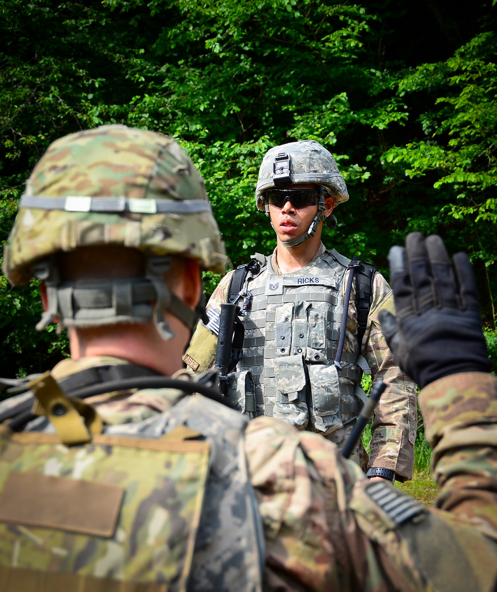 A student asks his squad leader, Tech. Sgt. Christopher Ricks, 86th Security Forces Squadron flight chief, a question about the mission on Baumholder, Germany, June 15, 2015.  Squad leaders provide leadership and guidance during mission operations.  (U.S. Air Force Photo/Tech. Sgt. Daylena S. Ricks)