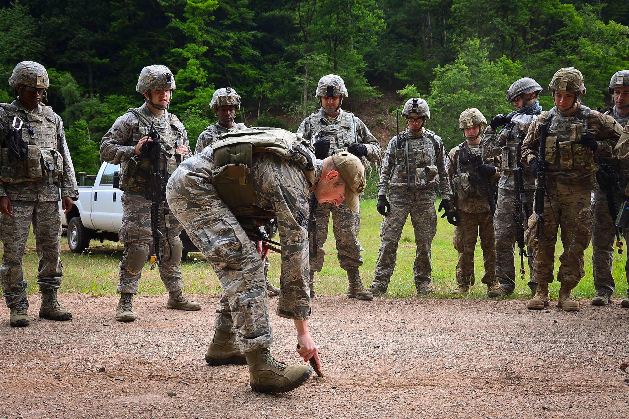 Staff Sgt. Timothy Kennedy, 435th Security Forces Squadron senior instructor, draws a line in the sand table on Baumholder, Germany, June 15, 2015.  Sand tables are used to conduct rehearsals prior to missions.  (U.S. Air Force Photo/Tech. Sgt. Daylena S. Ricks)