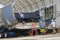 Members of the 502nd Trainer Development Squadron and aircraft transportation contractors work together to prepare a C-17 Globemaster III fuselage June 21 for its journey to its final destination at the U.S. Air Force School of Aerospace Medicine at Wright-Patterson Air Force Base, Ohio. There it will be reassembled into the first aeromedical evacuation training center for students at USAFSAM.  The transformation required a rebuild of the interior to replicate an actual C-17 that has the capability to transport patients. The fuselage was also engineered to provide several simulated capabilities to include sounds, temperature changes, smoke and other variances to provide a realistic C-17 aeromedical training environment. (U.S. Air Force photo by Senior Airman Alexandria Slade)
