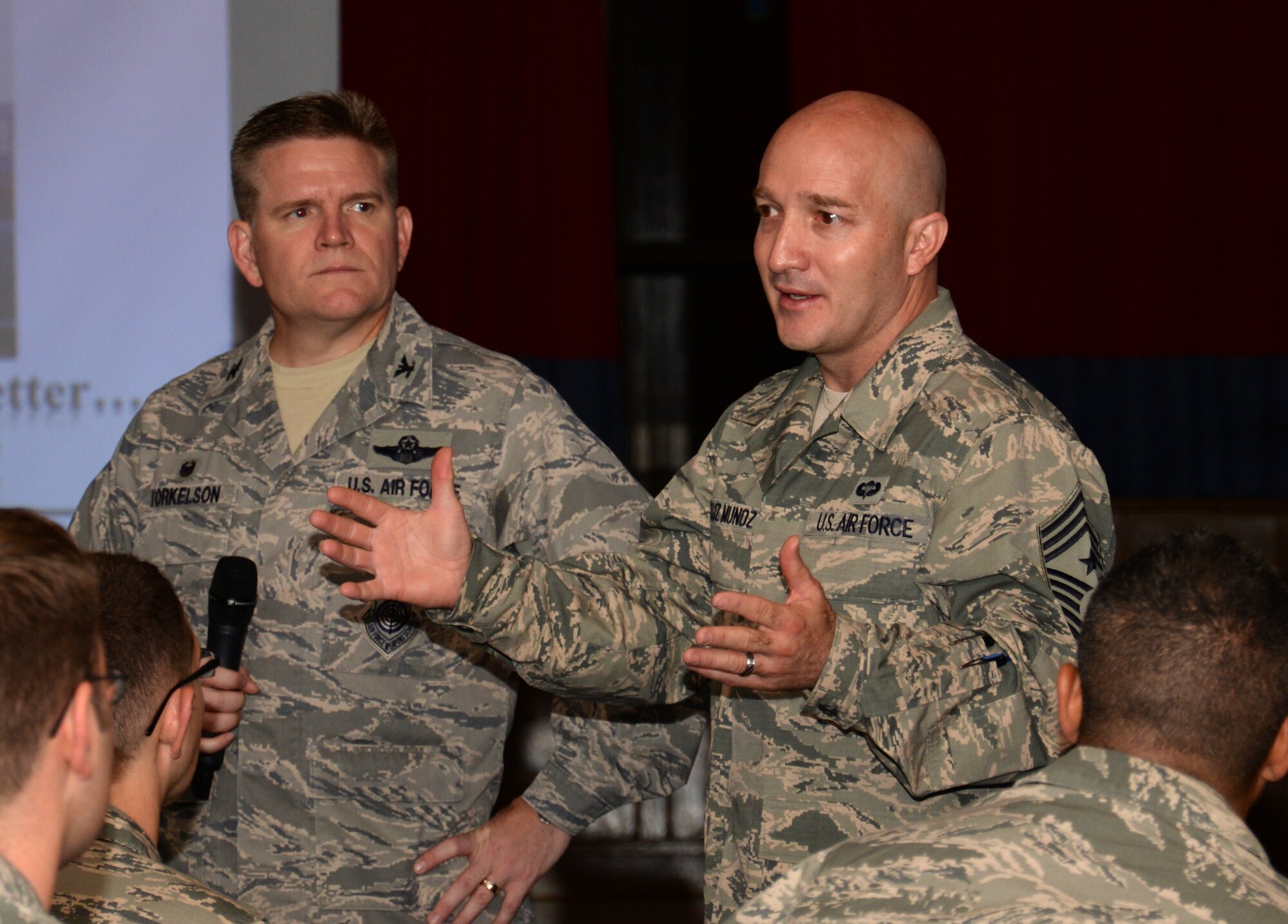 U.S. Air Force Chief Master Sgt. Anthony Cruz Munoz, right, 100th Air Refueling Wing command chief, speaks to Team Mildenhall members during a commander's call with U.S. Air Force Col. Thomas D. Torkelson, 100th ARW commander, June 23, 2015, on RAF Mildenhall, England. Following a briefing, Torkelson opened the floor for questions from the group. (U.S. Air Force photo by Gina Randall/Released)