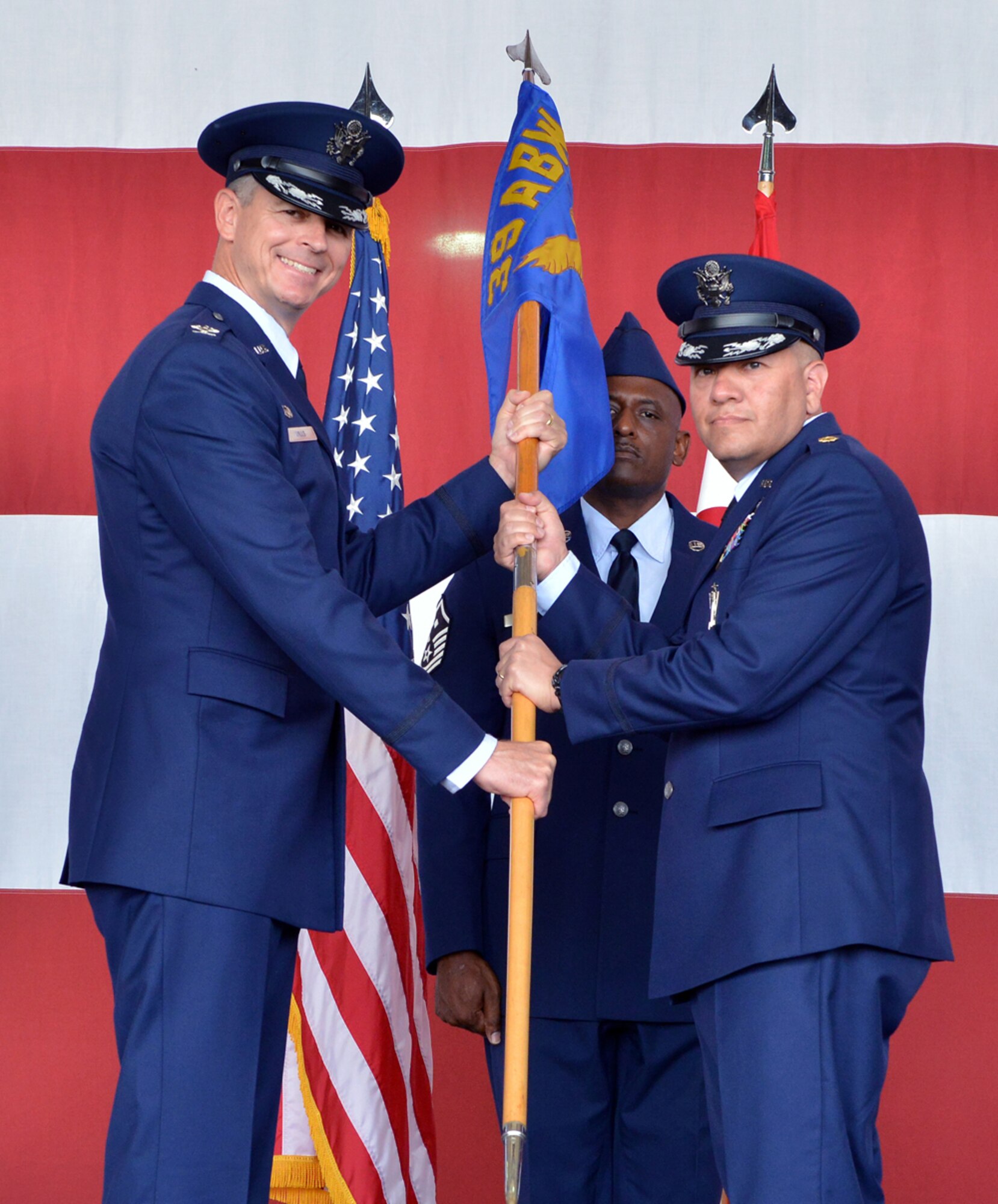 Col. Craig Wills, 39th Air Base Wing commander, passes the guidon Maj. John Mora, 39th Maintenance Squadron commander, during the 39th MXS change of command ceremony June 23, 2015, at Incirlik Air Base, Turkey. A change of command ceremony is a tradition that represents a formal transfer of authority and responsibility from the outgoing commander to the incoming commander. (U.S. Air Force photo by Senior Airman Michael Battles/Released)