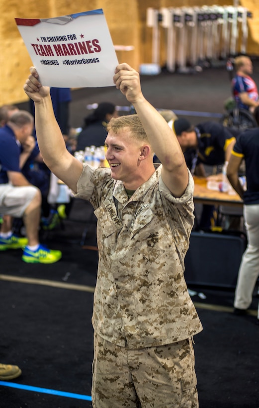 U.S. Marine Corps Lance Cpl. Kristian Largent cheers on Team Marine Corps at the 2015 Department of Defense Warrior Games archery competition on Marine Corps Base  Quantico, Va., June 22, 2015.