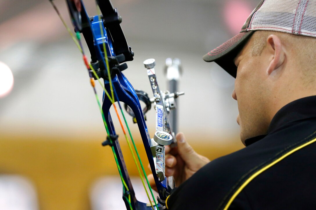 Army reserve Sgt. Colton Harms adjusts the sights on his bow during the archery competition at the 2015 Department of Defense Warrior Games on Marine Corps Base Quantico, Va., June 22, 2015.