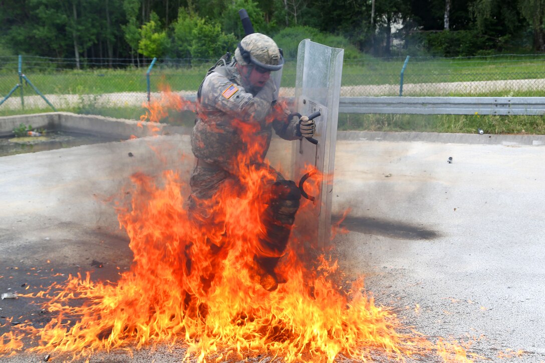 A U.S. soldier moves through fire during a fire phobia training exercise at the Joint Multinational Readiness Center in Hohenfels, Germany, June 16, 2015.