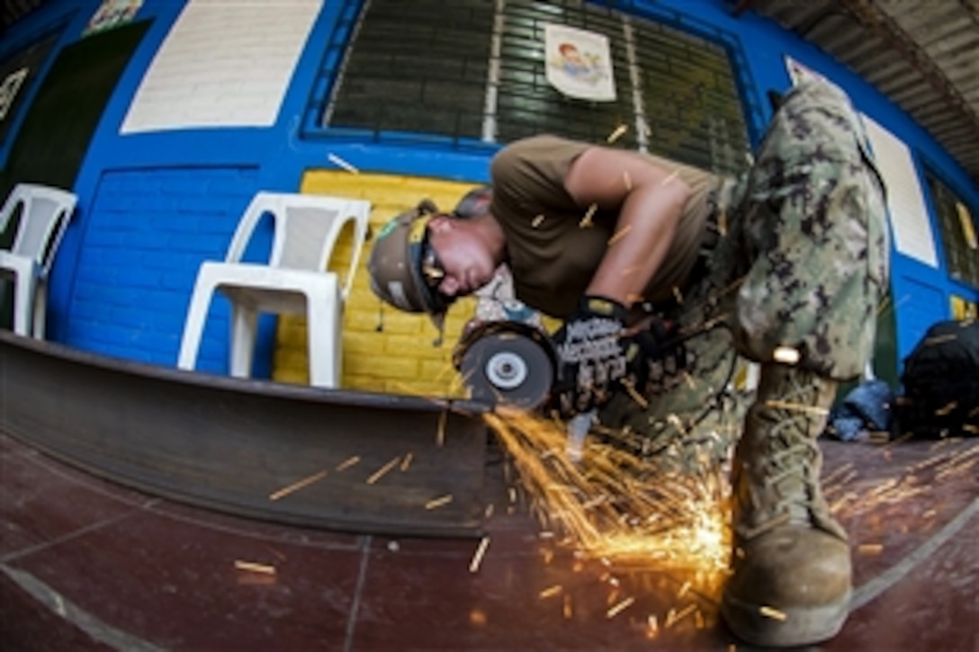 U.S. Navy Seaman Chelsea Turner cuts a metal beam at an engineering site at Escuela de Education Especial de Acajutla during Continuing Promise 2015 in Acajutla, El Salvador, June 21, 2015. Turner is a builder constructionman assigned to Construction Battalion Maintenance Unit 202.