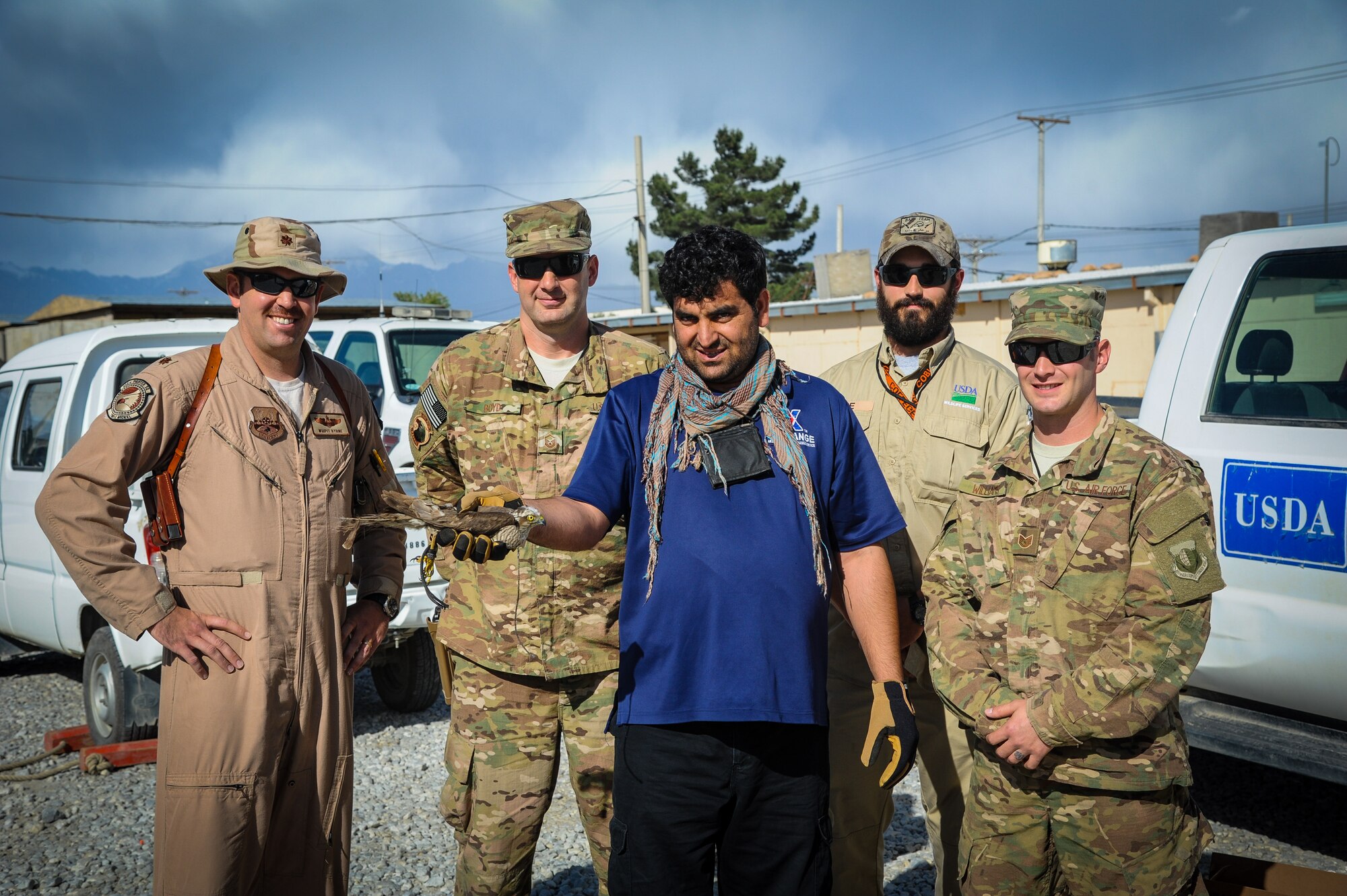 The 455th Air Expeditionary Wing safety office and a local Afghan pose for a photo with a captured bird April 30, 2015, at Bagram Airfield, Afghanistan. The team assisted the wildlife biologist in rescuing the falcon. (U.S. Air Force photo by Maj. Tony Wickman/Released)