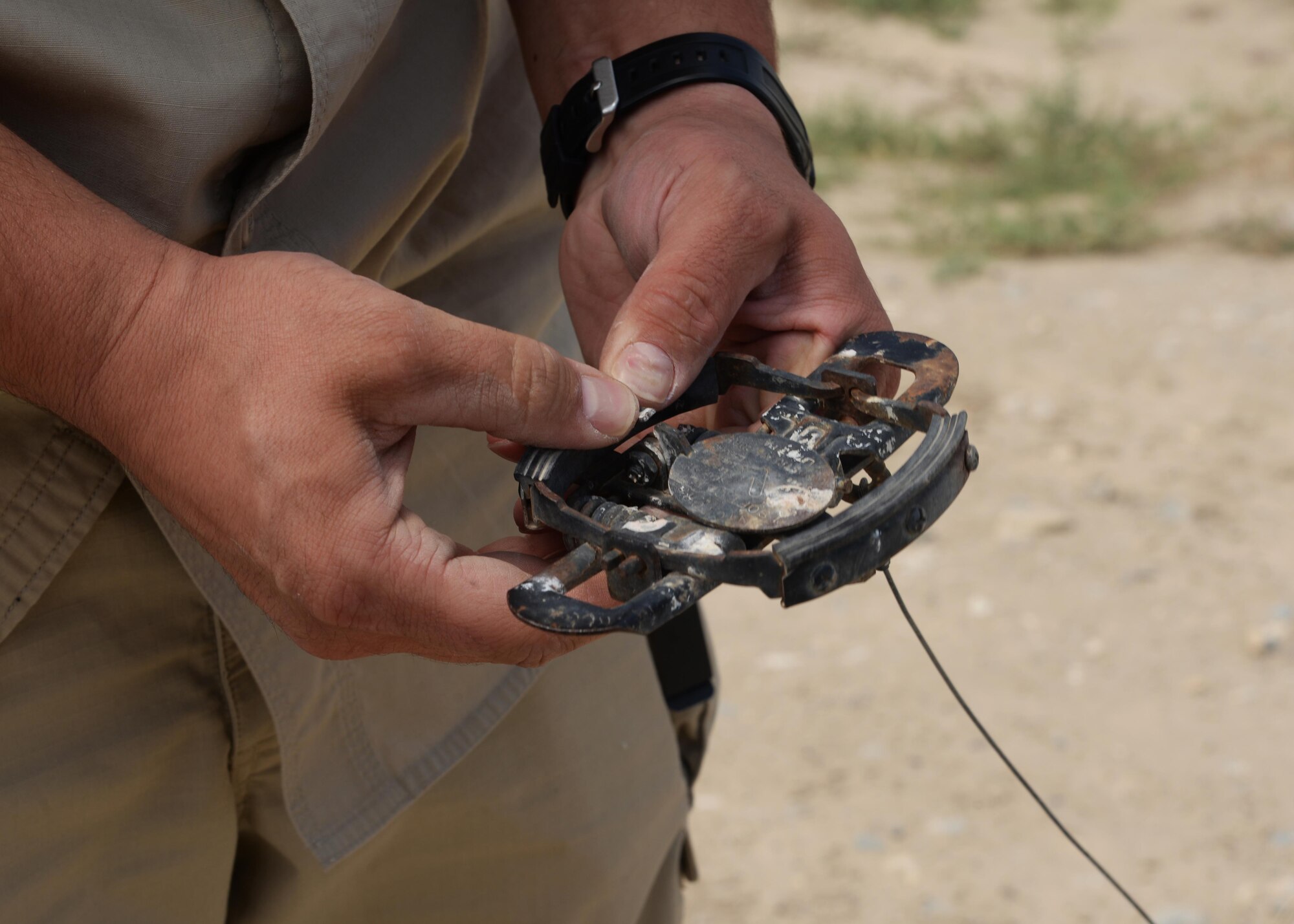 Matthew Gage, 455th Expeditionary Safety Office wildlife biologist, sets up a bird trap on the Airfield, June 22, 2015, at Bagram Airfield, Afghanistan. Gage is responsible for safely removing animals and birds that cause a risk to flight line and aircraft operations. (U.S. Air Force photo by Senior Airman Cierra Presentado/Released)