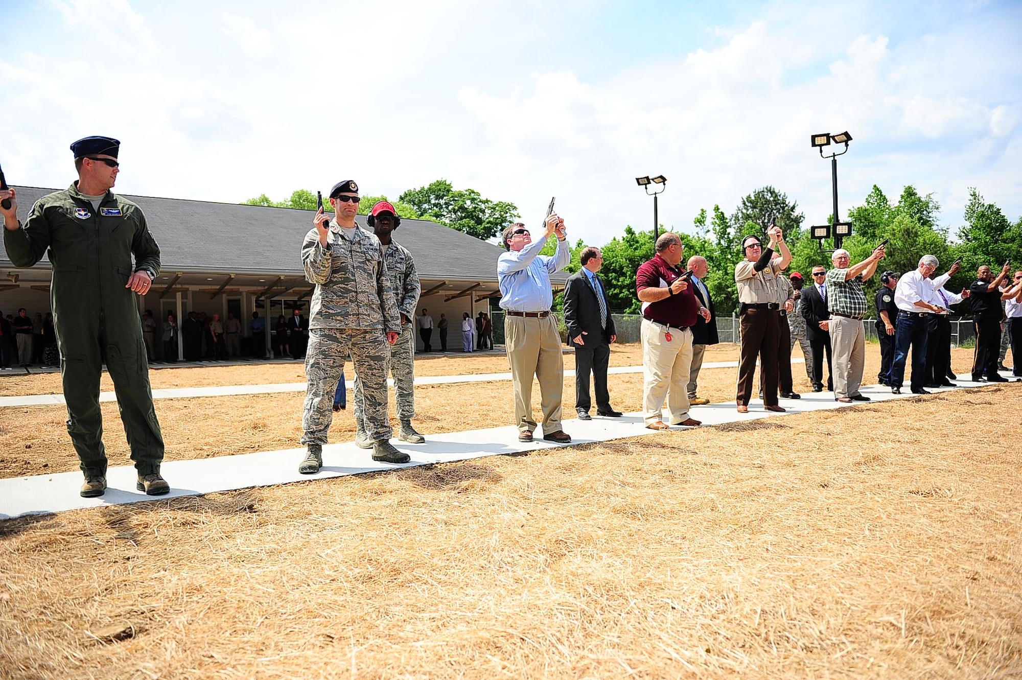 Col. John Nichols, 14th Flying Training Wing Commander, and Maj. Brenton Pickrell, 14th Security Forces Squadron Commander, lead a line of 14 shooters to officially open the Columbus Lowndes County Small Arms Range May 8 in Lowndes County, Mississippi. Distinguished shooters included Mississippi Governor Phil Bryant and other local community members who contributed to the planning and construction of the $1.9 million facility. (U.S. Air Force photo by Airman Daniel Lile)