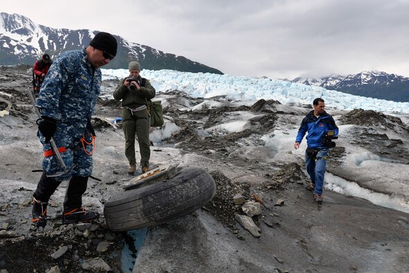 Navy Lt. Cmdr. Paul Cocker (left), the Alaskan Command deputy chief of future operations and Operation Colony Glacier project officer, shows local media some of the aircraft debris from the 1952 C-124 Globemaster II accident, June 10, 2015. Each summer since 2012, ALCOM has supported Operation Colony Glacier by removing aircraft debris and assisting in the recovery of human remains to ensure closure for families who have lost loved ones. (U.S. Air Force photo/Tech. Sgt. John Gordinier) 