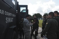 Staff Sgt. Natividad Jurado Jr., Inter-American Air Forces Academy international force protection instructor, answers questions about the armored vehicle provided by the Alamo Area Council of Governments for use in the Special Reactions Team training seminar June 15. The seminar at the IAAFA Training Center was conducted by the Bexar County Sheriff’s
Office SWAT team, and covered the training the team performs and the equipment they use.(U.S. Air Force photo/Jose T. Garza III)