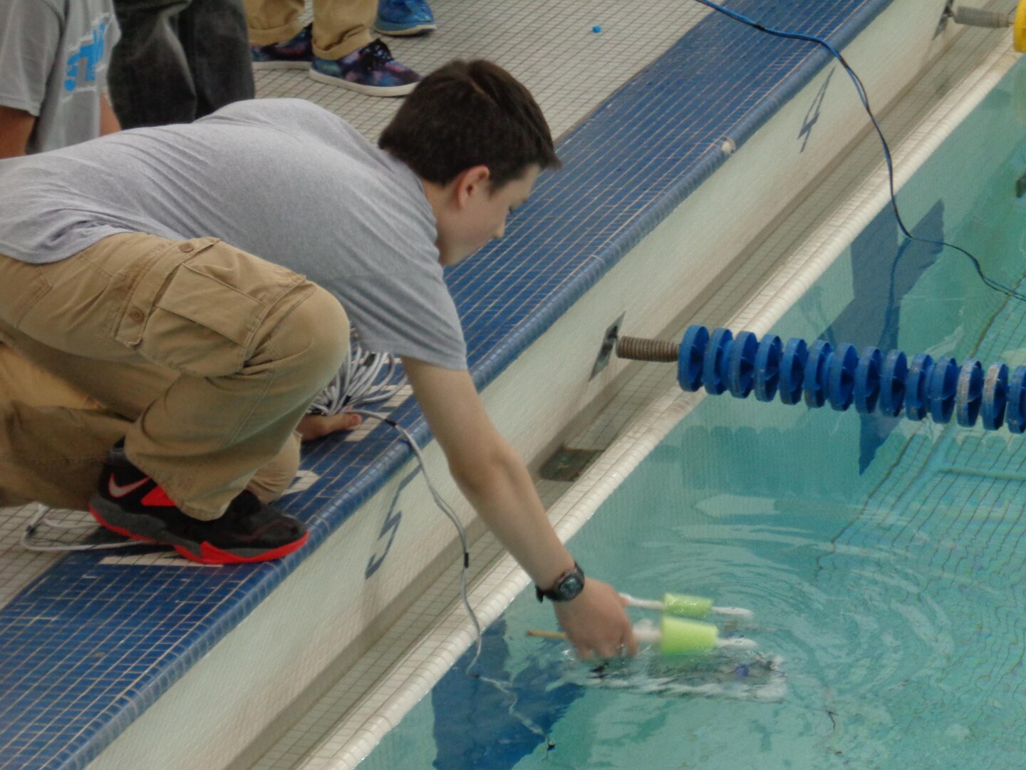 A SeaPerch contestant launches his remotely operated vehicle to complete in the underwater obstacle course during regional competition in Philadelphia.