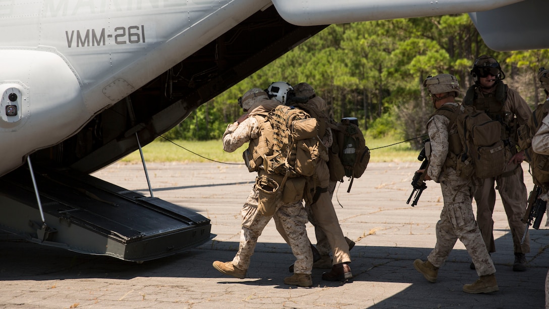 Marines with Lima Co., 3rd Battalion, 8th Marine Regiment, guide a role player acting as a downed pilot to an MV-22B Osprey during a tactical recovery of aircraft and personnel exercise aboard Marine Corps Outlying Landing Field Atlantic, N.C., June 19, 2015. Due to the short notice nature of TRAP missions, the Marines stood by during the week to receive the mission, showing them the importance of maintaining readiness. The TRAP exercise was part of Special Purpose Marine Air-Ground Task Force Crisis Response-Africa’s certification exercise, the final step in their pre-deployment training. (U.S. Marine Corps photo by Cpl. Justin T. Updegraff/ Released)

