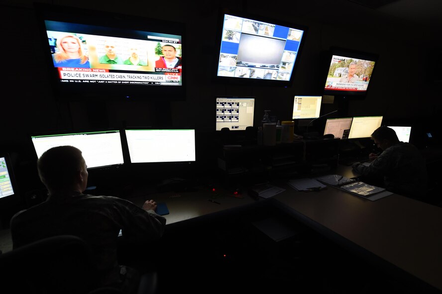 (From left) Airman 1st Class Nicholas Eastridge, 1st Special Operations Air Operations Squadron Command Post apprentice controller and Tech. Sgt. Robert Pyles, 1st SOAOS Command Post senior controller, stay on alert in the command post operations room, June 23, 2015, at Hurlburt Field, Fla. Airmen assigned to the command post act as a conduit of all communications, acting as a critical asset to base operations and the commander. (U.S. Air Force photo by Airman 1st Class Ryan Conroy/Released)
