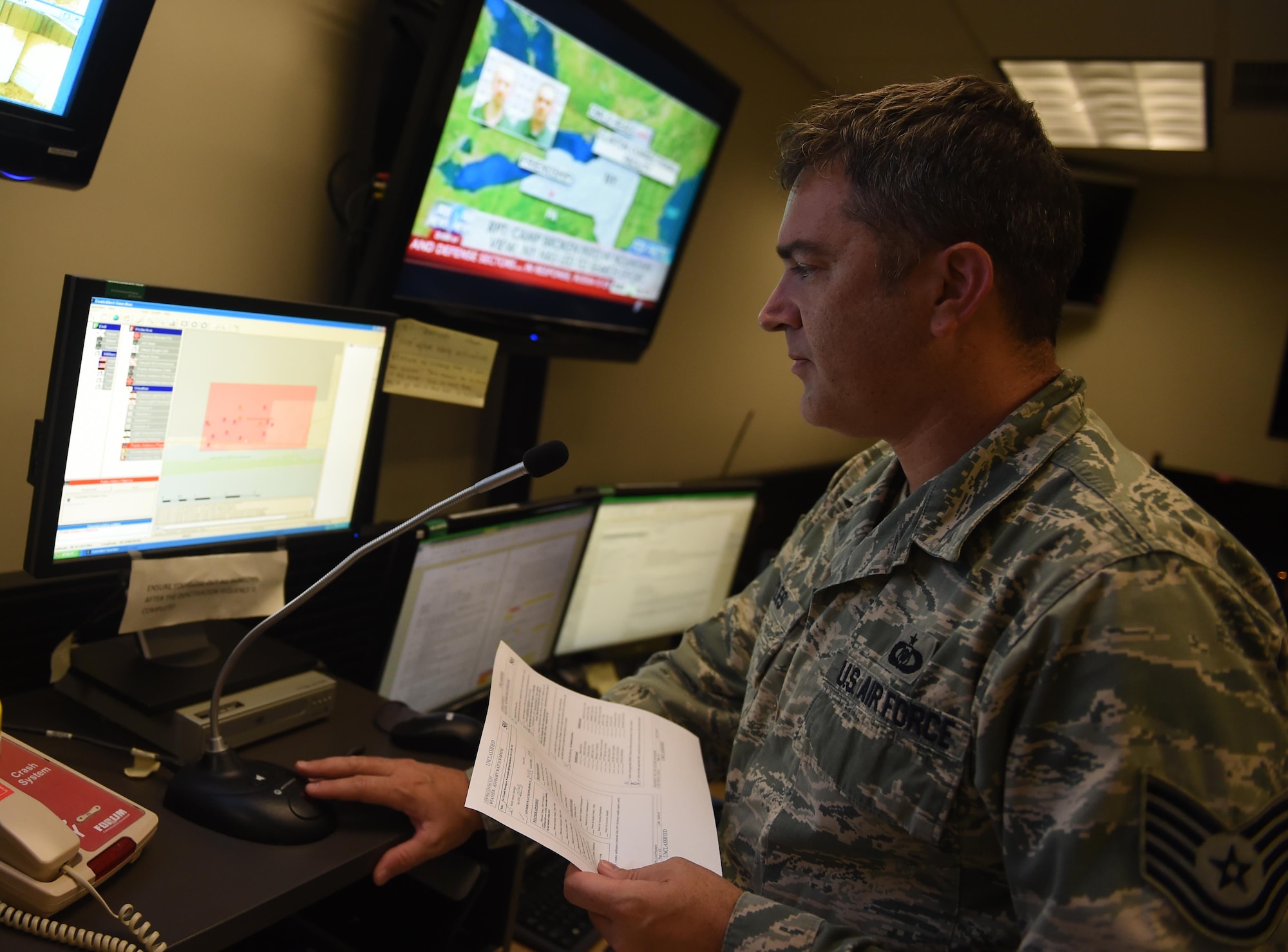 Tech. Sgt. Robert Pyles, 1st Special Operations Air Operations Squadron Command Post senior controller, transmits a message using the “Giant Voice” public address system, June 22, 2015, at Hurlburt Field, Fla. Airmen assigned to the command post act as a conduit of all communications, acting as a critical asset to base operations and the commander. (U.S. Air Force photo by Airman 1st Class Ryan Conroy/Released)