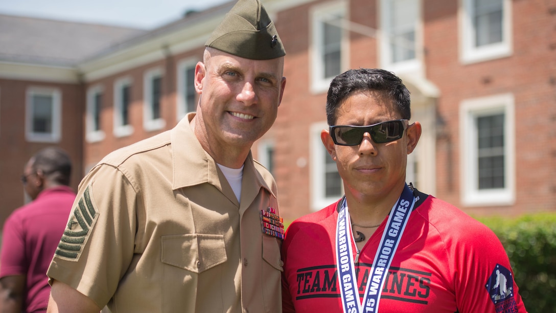 Sgt. Maj. Robert Vanoostrom and Anthony Rios poses for a photo during the cycling awards ceremony hosted in front of Lejeune Hall at Marine Corps Base Quantico, Virginia, June 21, 2015. Rios is a member of the 2015 Department of Defense (DoD) Warrior Games All-Marine Team. The 2015 DoD Warrior Games, held at MCB Quantico June 19-28, is an adaptive sports competition for wounded, ill, and injured Service members and veterans from the U.S. Army, Marine Corps, Navy, Air Force, Special Operations Command, and the British Armed Forces. 