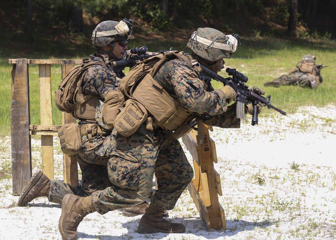 A Marine rifle squad advances while laying down suppressive fire during a squad assault exercise as part of the 2nd Marine Division Infantry Rifle Squad Competition aboard Camp Lejeune, N.C., June 18, 2015. Alpha Company, 1st Battalion, 2nd Marine Regiment; Bravo Company, 1st Battalion, 6th Marine Regiment and India Company, 3rd Battalion, 8th Marine Regiment proved their mission readiness and superior combat abilities while competing in a grueling three-day competition to foster a competitive spirit and unit cohesion and to determine the most proficient and capable rifle squad in 2nd Marine Division. (U.S. Marine Corps photo by Cpl. Michelle Reif/Released)