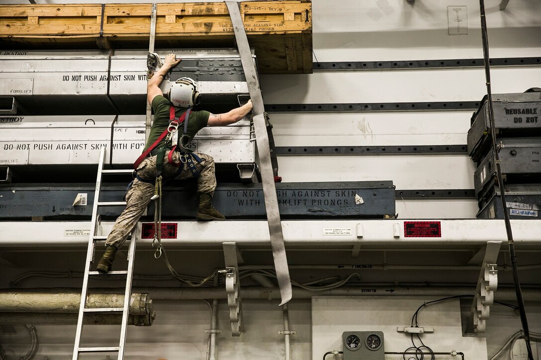A U.S. Marine with the 15th Marine Expeditionary Unit moves equipment in the hangar bay aboard the USS Essex (LHD 2). The Marines and Sailors aboard the Essex work day and night to ensure all gear and equipment is in good condition and they are prepared for anything at a moment’s notice. The 15th MEU is embarked on the Essex Amphibious Ready Group and deployed to maintain regional security in the U.S. 5th Fleet area of operations. (U.S. Marine Corps photo by Cpl. Anna Albrecht/Released)