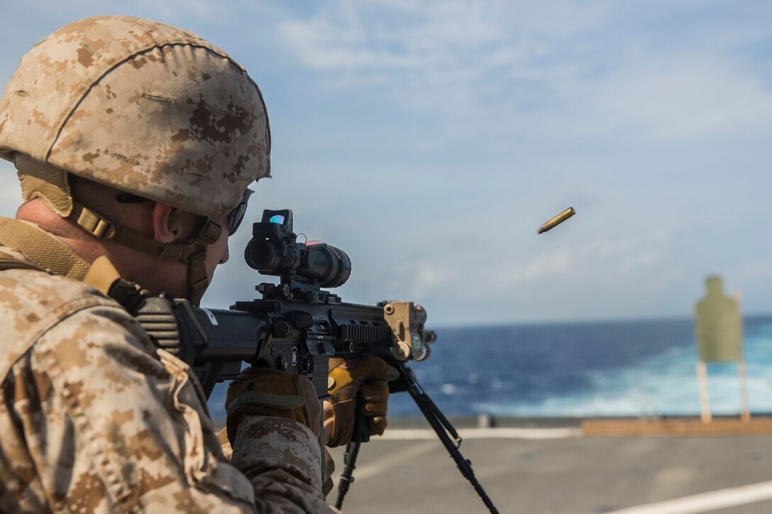 U.S. Marine Lance Cpl. Alexander Bastin fires at his target during a short-range marksmanship qualification course aboard the USS Rushmore (LSD 47) at sea in the Indian Ocean, June 18, 2015. Bastin is an automatic rifleman with Kilo Company, Battalion Landing Team 3rd Battalion, 1st Marine Regiment, 15th Marine Expeditionary Unit. The marksmanship course improves Marine’s combat shooting tactics and prepares them for future operations while deployed with the 15th MEU. (U.S. Marine Corps photo by Sgt. Emmanuel Ramos/Released)