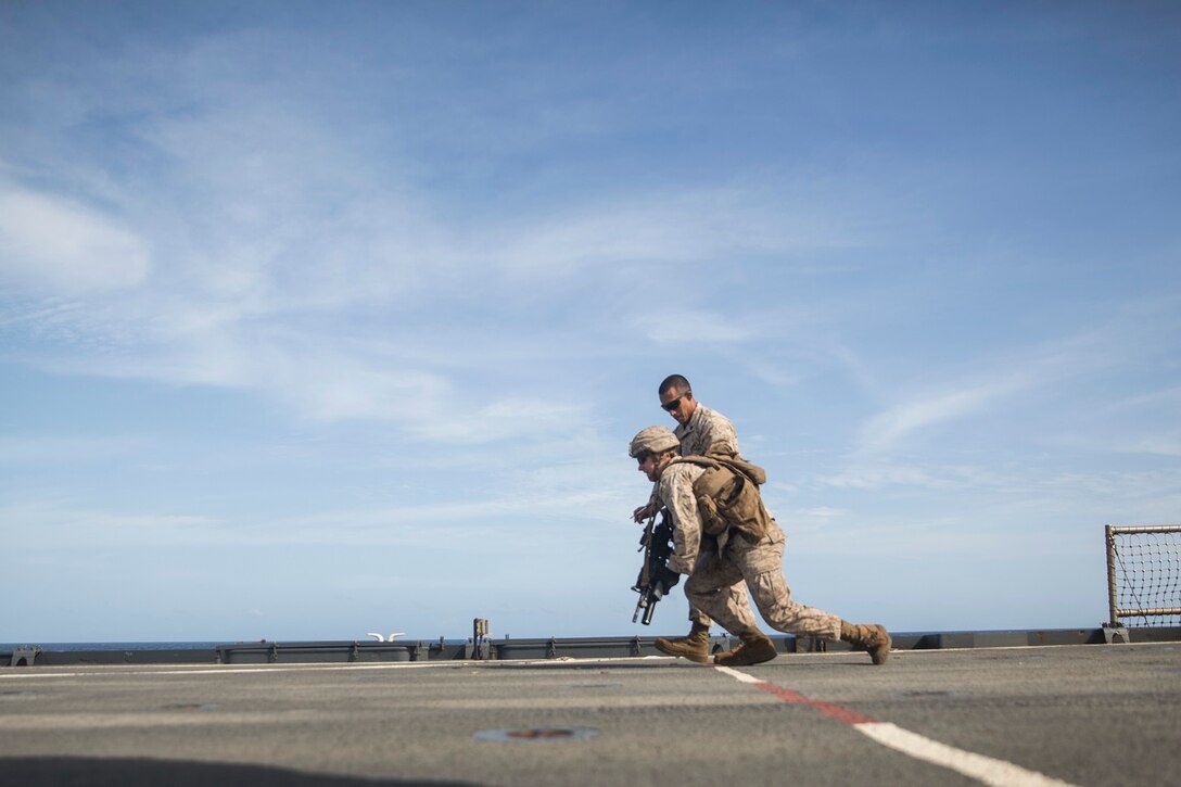U.S. Marine Justin Saafeld moves to his next shooting position during a short-range marksmanship qualification course aboard the USS Rushmore (LSD 47) at sea in the Indian Ocean, June 18, 2015. Saafeld is an assaultman with Kilo Company, Battalion Landing Team 3rd Battalion, 1st Marine Regiment, 15th Marine Expeditionary Unit. The marksmanship course improves Marine’s combat shooting tactics and prepares them for future operations while deployed with the 15th MEU. (U.S. Marine Corps photo by Sgt. Emmanuel Ramos/Released)