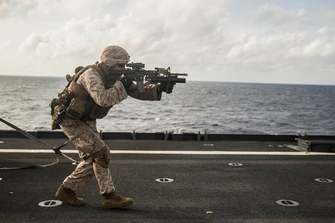 U.S. Marine Joseph Burk fires at his target on the move during a short-range marksmanship qualification course aboard the USS Rushmore (LSD 47) at sea in the Indian Ocean, June 18, 2015. Burk is a team leader with Kilo Company, Battalion Landing Team 3rd Battalion, 1st Marine Regiment, 15th Marine Expeditionary Unit. The marksmanship course improves Marine’s combat shooting tactics and prepares them for future operations while deployed with the 15th MEU. (U.S. Marine Corps photo by Sgt. Emmanuel Ramos/Released)