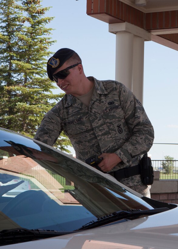 Airman 1st Class Dylan Westmoreland, 90th Security Forces Squadron, conducts a routine I.D. check at the front gate on F.E. Warren Air Force Base, Wyo., June 19, 2015. Conducting entry control to the base is one of the roles Westmoreland performs in providing safety and security for the base. (U.S. Air Force photo by Lan Kim)