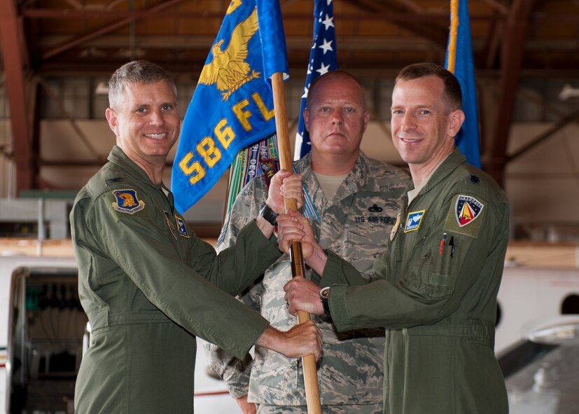 Lieutenant Col. Nathan Diller, 586th Flight Test Squadron incoming commander, accepts the 586th FLTS guidon from Col. Hans Miller, 96th Test Group commander, symbolizing his assumption of command during the 586th FLTS Change of Command at Holloman Air Force Base, N.M., June 24, 2015. Diller assumed command of the 586th FLTS from Lt. Col. Steven Ross. The 586th FLTS tests guidance systems, laser systems, air-to-air and air-to-ground systems, long-range and standoff weapons, live warheads and provides target, photo and safety chase. (U.S. Air Force photo by Staff Sgt. Joe Laws / Released)