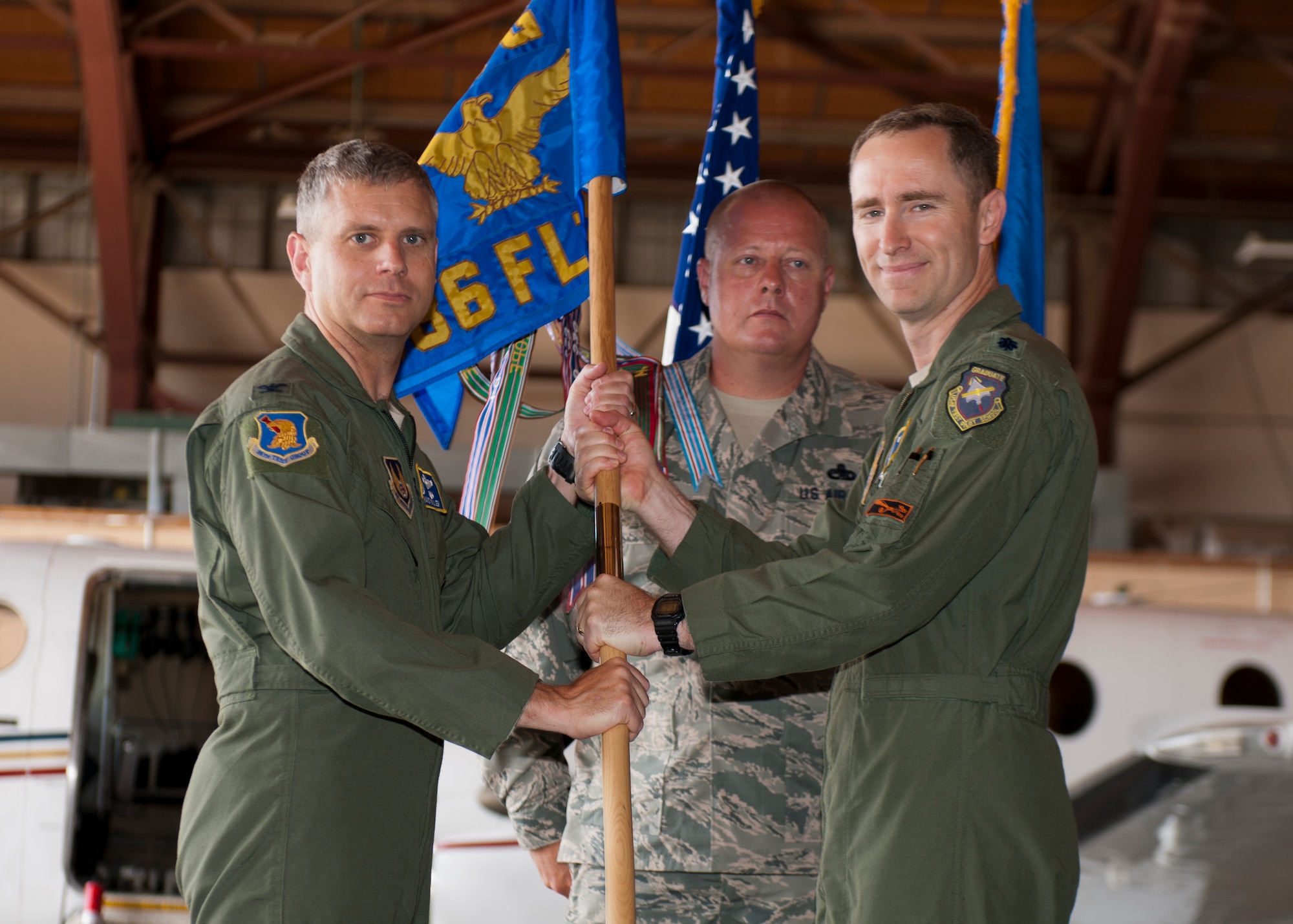 Lieutenant Col. Steven Ross, 586th Flight Test Squadron outgoing commander, passes the 586th FLTS guidon to Col. Hans Miller, 96th Test Group commander, symbolizing his stepping down from command during the 586th FLTS Change of Command at Holloman Air Force base, N.M., June 24, 2015. Lt. Col. Nathan Diller assumed command of the 586th FLTS from Ross. The 586th FLTS tests guidance systems, laser systems, air-to-air and air-to-ground systems, long-range and standoff weapons, live warheads and provides target, photo and safety chase. (U.S. Air Force photo by Staff Sgt. Joe Laws / Released)