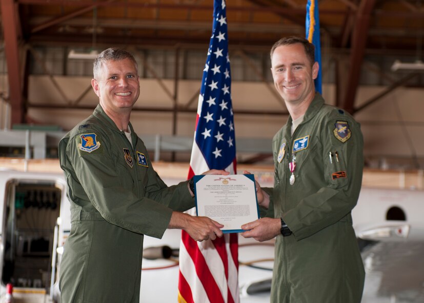 Lieutenant Col. Steven Ross, 586th Flight Test Squadron outgoing commander, receives a Meritorious Service Medal from Col. Hans Miller, 96th Test Group commander, during the 586th FLTS Change of Command at Holloman Air Force Base, N.M., June 24, 2015. Lt. Col. Nathan Diller assumed command of the 586th FLTS from Lt. Col. Steven Ross. Diller will use his 15 years of experience to assist the 586th FLTS in their mission of flight testing guidance systems, laser systems, air-to-air and air-to-ground systems, long-range and standoff weapons, live warheads and provides target, photo and safety chase. (U.S. Air Force photo by Staff Sgt. Joe Laws / Released)
