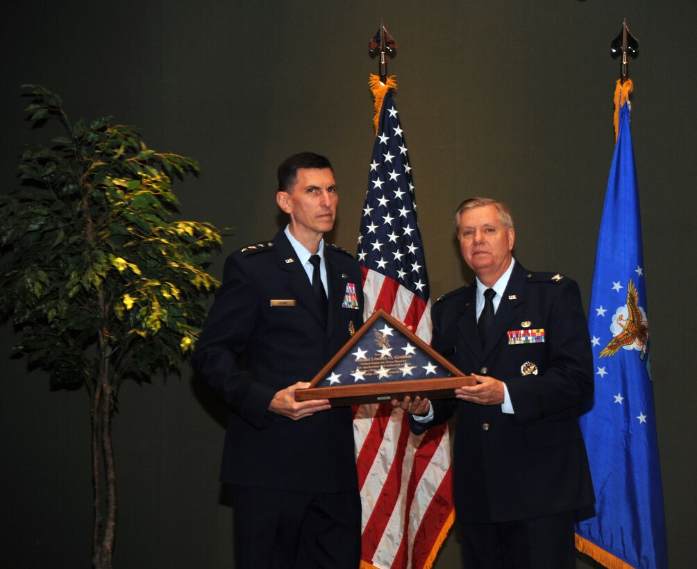 Lt. Gen. Christopher F. Burne, The Judge Advocate General, Headquarters U.S. Air Force, presents a U.S. flag to Col. Lindsey Graham upon his retirement at the National Guard Memorial Museum. Senator Graham is retiring after three decades of service with the United States Air Force Reserve. Col. Graham is also the incumbent U.S. Senator of South Carolina. (U.S. Air National Guard photo by Airman 1st Class Anthony Small)