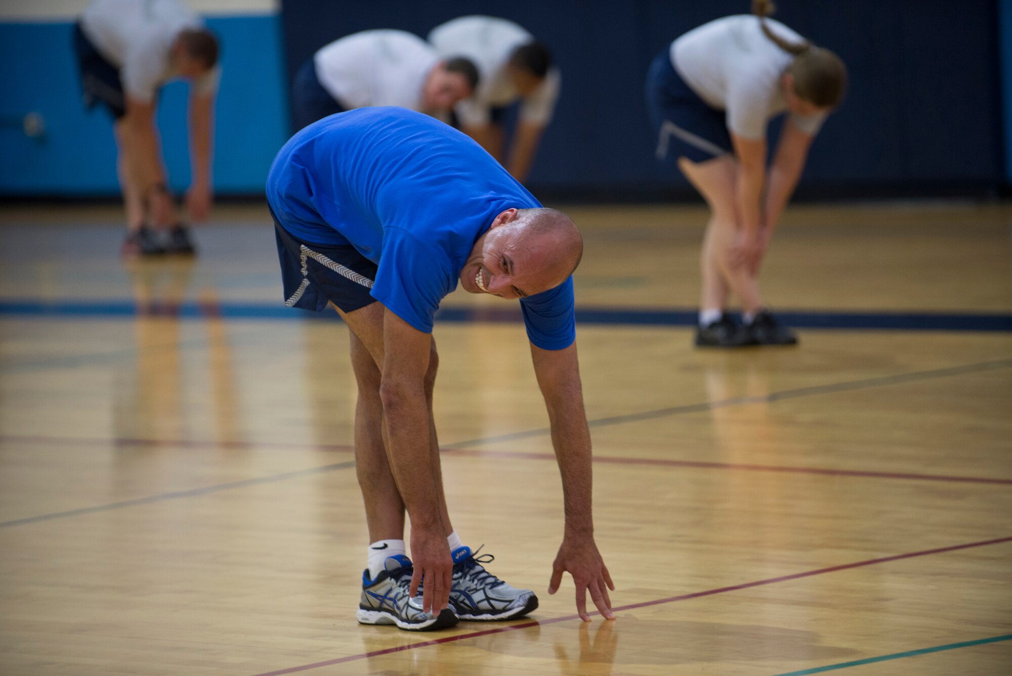 Royce Gracie stretches with Airmen during a group work out at the James Gym, Scott Air Force Base, Illinois, June 17, 2015. The fighters taught Airmen fighting techniques after the PTLs warmed them up. (U.S. Air Force Photo by Airman 1st Class Megan Friedl)