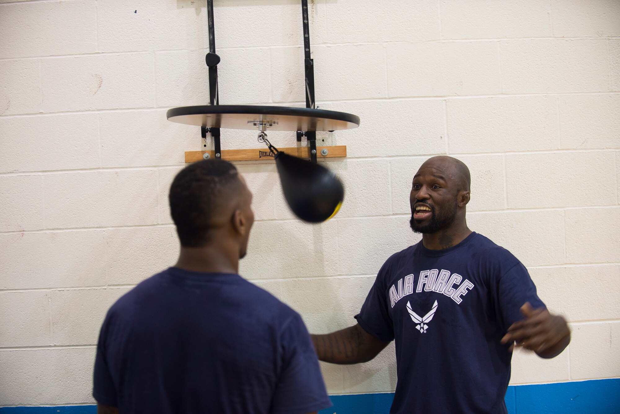 “King Mo” Lawal  and Will Brooks, Mixed Martial Arts fighter practice punching a punching bag at the James Gym, Scott Air Force Base, Illinois, June 17, 2015. The fighters practiced their punches and discussed different techniques. (U.S. Air Force Photo by Airman 1st Class Megan Friedl)