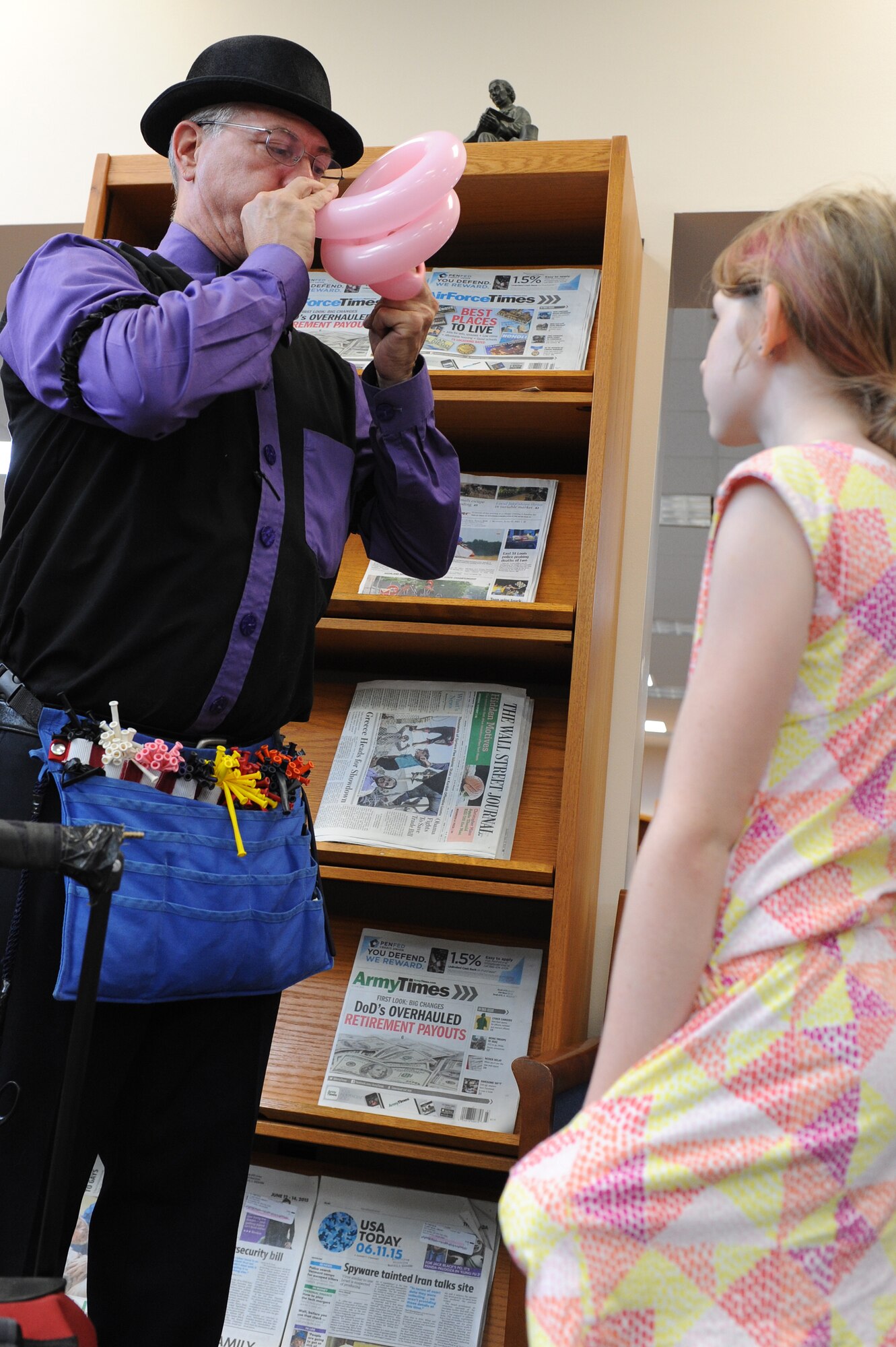 Sterling Dare, entertainer, blows up a balloon for a child during the Read to the Rhythm Summer Reading Program kick-off event at the library at Scott Air Force Base, Illinois. The event invited members of Team Scott to have fun reading during the summer and earn prizes at the same time. (U.S. Air Force photo by Senior Airman Sarah Hall-Kirchner/Released)