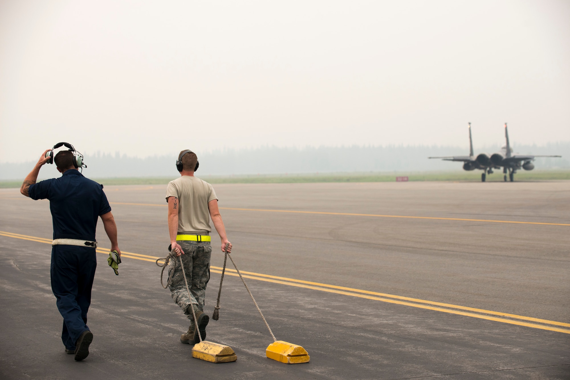 U.S. Air Force Tech. Sgt. Mathew Mains and Senior Airman Caleb Ross, both 4th Fighter Wing crew chiefs, watch an F-15E Strike Eagle aircraft assigned to the 4th Fighter Wing, Seymour Johnson Air Force Base, N.C., taxis prior to takeoff after an end of runway inspection, June 23, 2015, during the Northern Edge 2015 exercise at Eielson Air Force Base, Alaska. End of runway inspections allow crew chiefs to ensure the serviceability of aircraft prior to takeoff. (U.S. Air Force photo by 1st Lt. Elias Zani/Released)