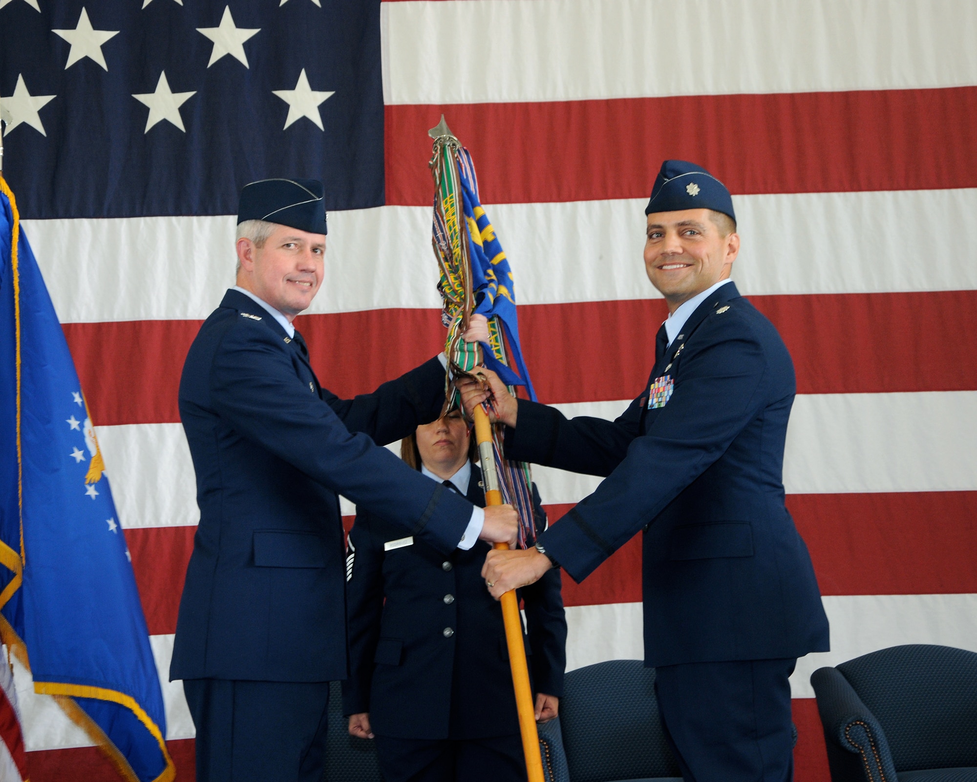 Col. James Boster, 14th Operations Group Commander, hands the 49th Fighter Training Squadron guidon to Lt. Col. David Bickerstaff, the new 49th FTS Commander, at a change of command ceremony June 19 at the firehouse.  The 49th FTS conducts Introduction to Fighter Fundamentals flying training for over 80 U.S. Air Force pilots, international pilots and Weapon System Officers annually. (U.S. Air Force photo/Melissa Doublin)