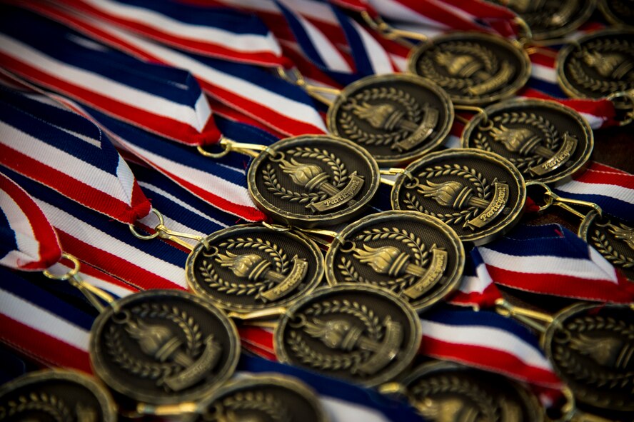 Olympic Day participation medals sit in a row June 12, 2015, at Moody Air Force Base, Ga. Olympic Day was established in 1948 to commemorate the birth of the Olympic Games and to promote fair-play, perseverance, respect and sportsmanship. (U.S. Air Force photo by Senior Airman Ryan Callaghan/Released)