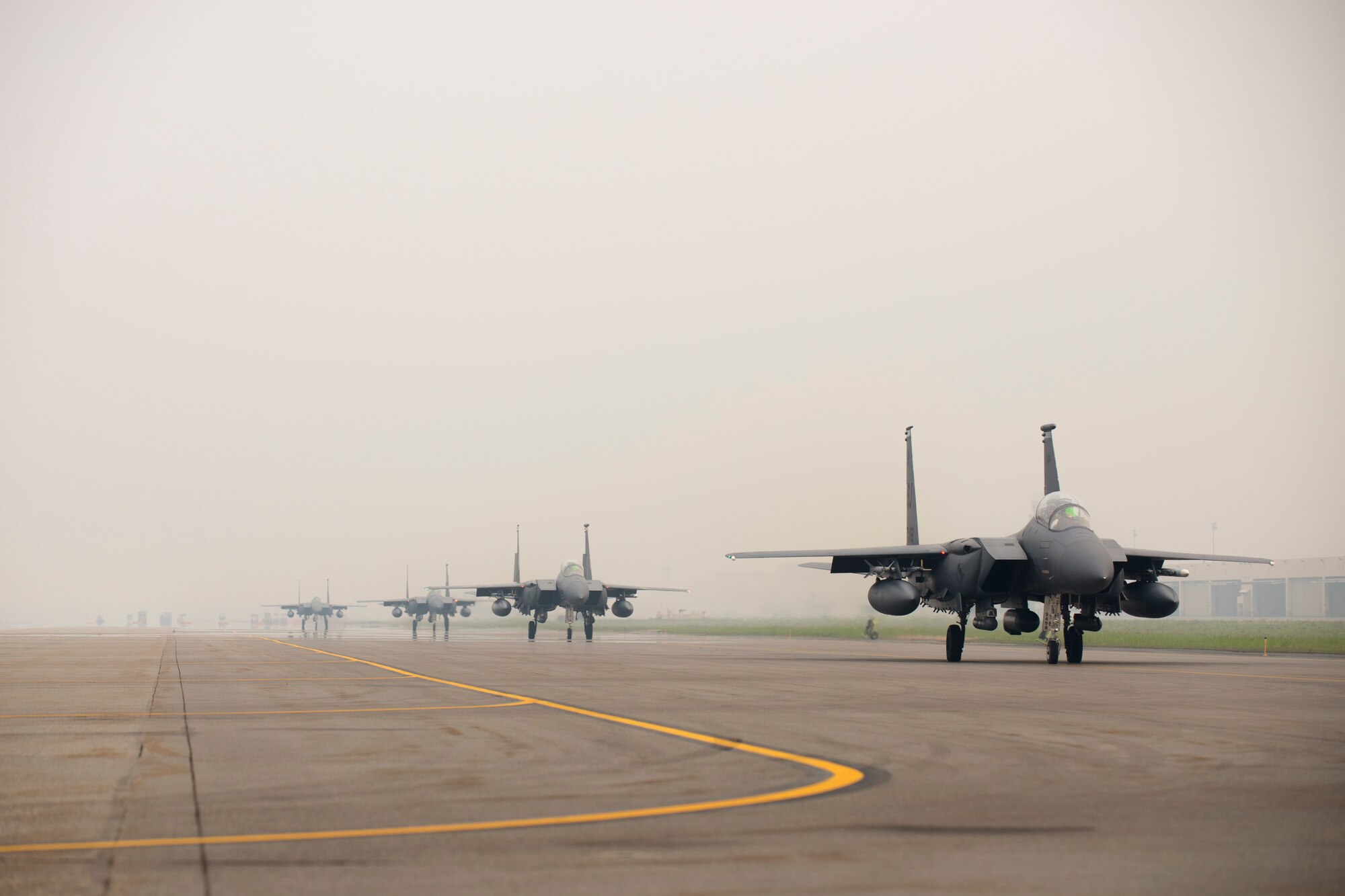 U.S. Air Force F-15E Strike Eagle aircraft assigned to the 4th Fighter Wing, Seymour Johnson Air Force Base, N.C., taxi through the smoky haze of nearby wildfires June 23, 2015, during Exercise Northern Edge, at Eielson Air Force Base, Alaska. Northern Edge 2015 is Alaska’s premier joint training exercise designed to practice operations, techniques and procedures as well as enhance interoperability among the services. (U.S. Air Force photo by 1st Lt. Elias Zani/Released)