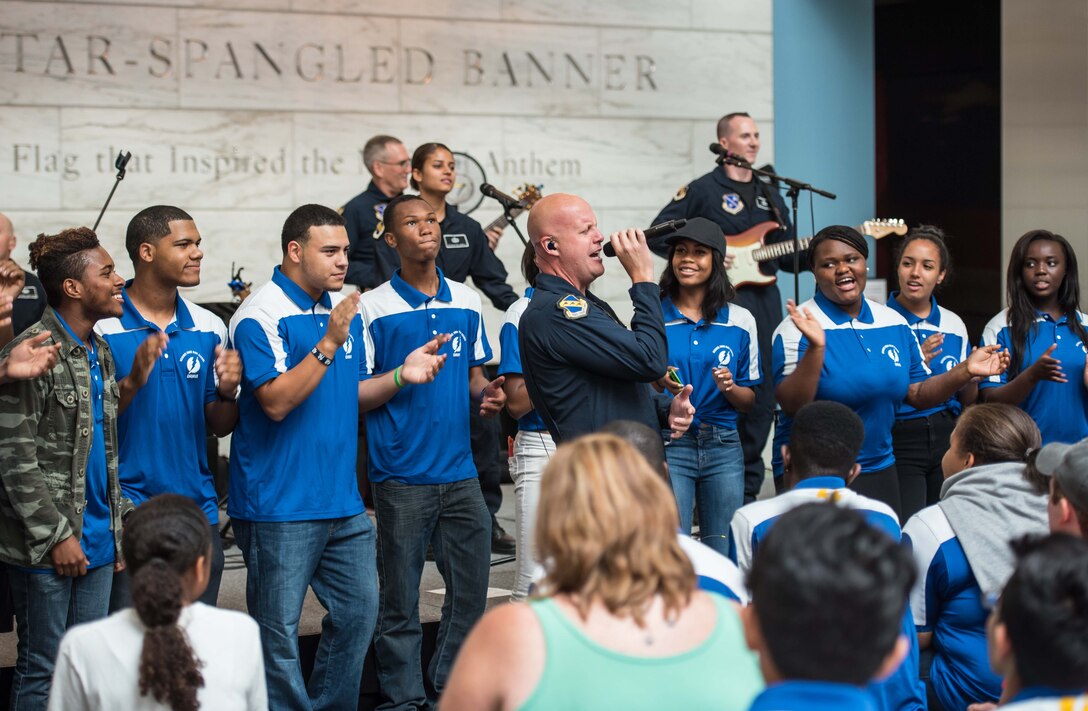 Senior Master Sergeant Ryan Carson has some audience members join him as back-up singers at Max Impact's recent performance at the Smithsonian Museum of American History. (U.S. Air Force Photo by Senior Master Sgt Kevin Burns/released)