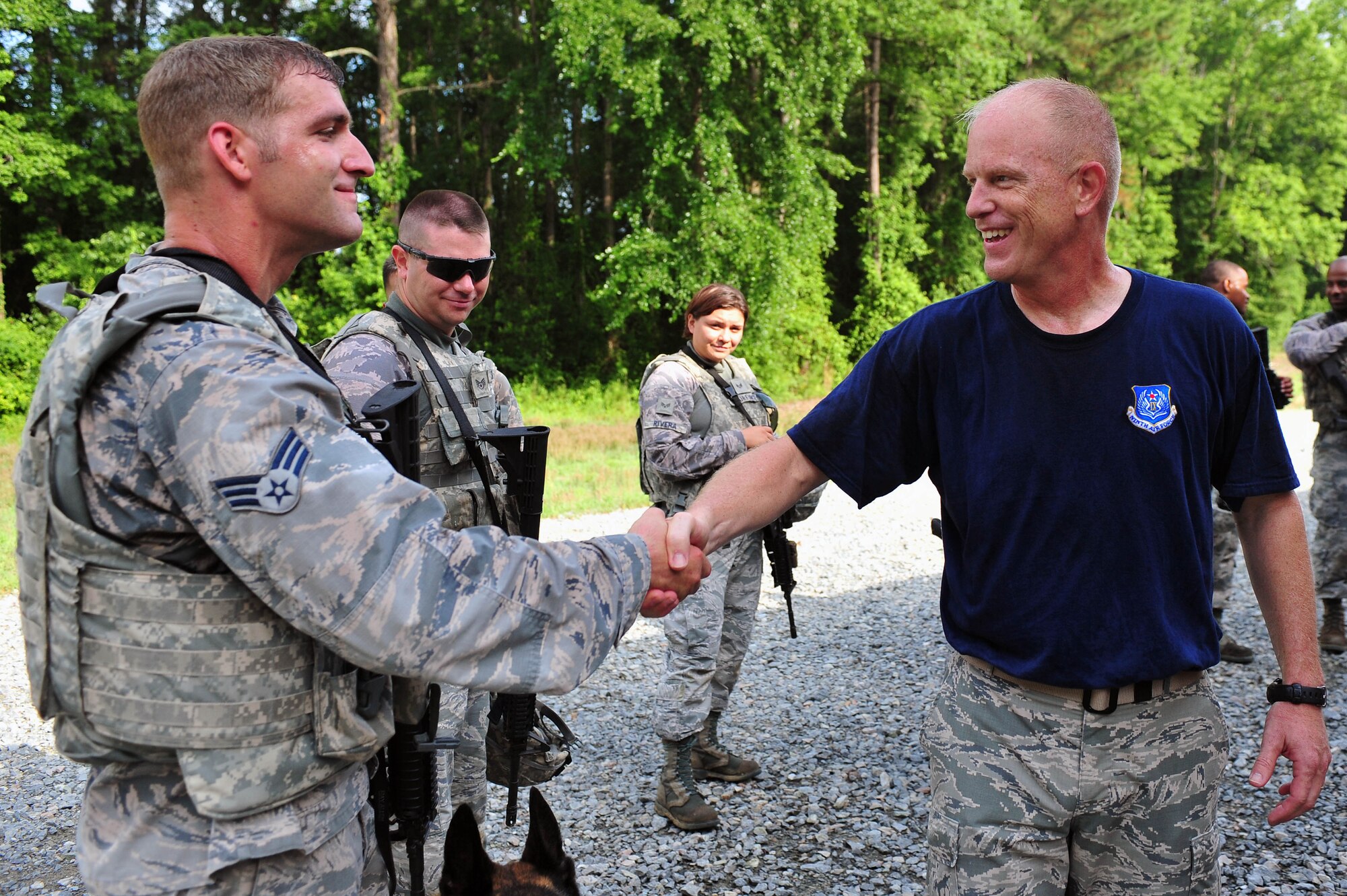 Chief Master Sgt. Frank Batten, Ninth Air Force command chief, shakes hands with Senior Airman Austin Craven, 4th Security Forces Squadron military working dog handler at Seymour Johnson Air Force Base, North Carolina, June 19, 2015. Batten was appointed the 9th AF command chief approximately one month ago. (U.S. Air Force photo by Senior Airman John Nieves Camacho/Released)


